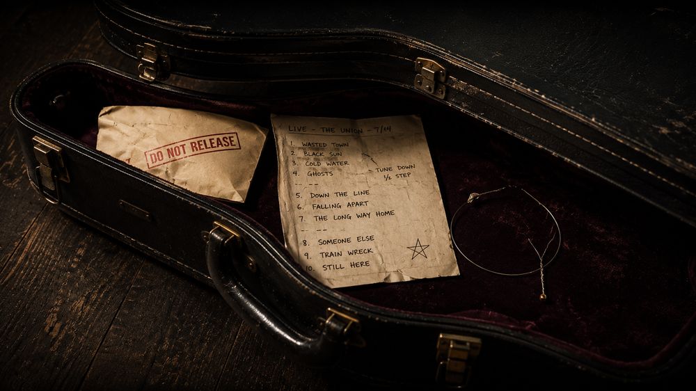 An open guitar case with old notes and papers